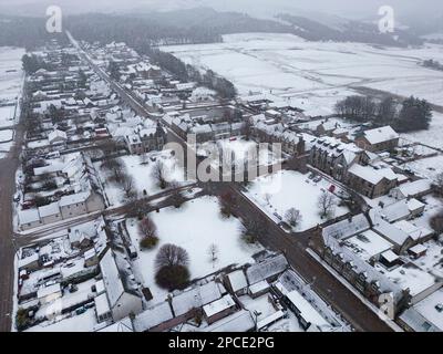 Tomintoul, Moray, Scozia, Regno Unito. 13 marzo 2023. Veduta aerea della piazza del villaggio a Tomintoul in Moray coperto di neve. Si prevede che la Scozia si trovi in stato di pressione Foto Stock