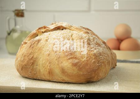 Una pagnotta di pane appena sfornato su un asciugamano. Pane fatto in casa delizioso e sano. Vista laterale Foto Stock