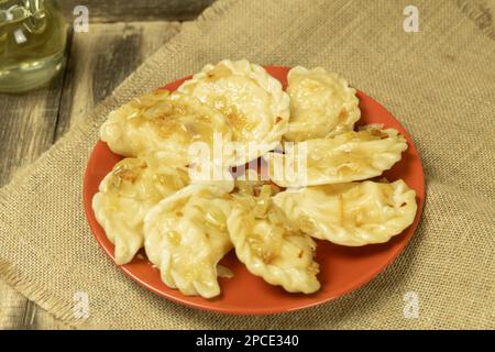 Gnocchi deliziosi e preparati al momento su un piatto. Gnocchi con qibuli fritti, primo piano Foto Stock
