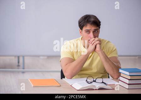 Giovane studente seduto in classe Foto Stock