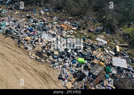 Incredibile inquinamento ecologico in Ungheria. Vicino a una città, c'è un sacco di rifiuti che si trovano accanto a una strada sterrata al confine. Inquinamento. Dumping illegale. Foto Stock