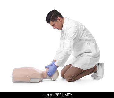 Medico in uniforme praticando il primo soccorso sul manichino su sfondo bianco Foto Stock