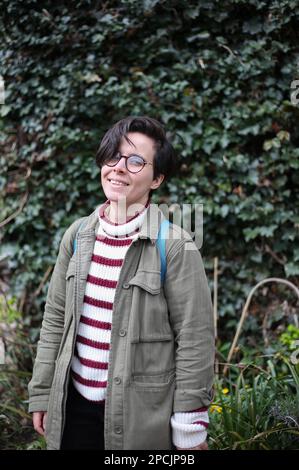 Ragazza in piedi di fronte a Ivy Foto Stock
