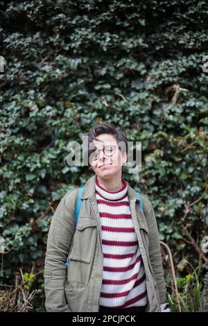 Ragazza in piedi di fronte a Ivy Foto Stock