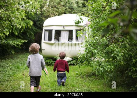 due bambini che camminano verso una carovana d'epoca Foto Stock