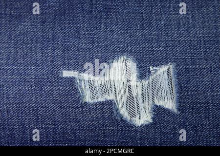 Tessuto jeans strappato, tessuto texture sfondo strappato. Tessuto tessuto di jeans strappato materiale tessile. Foto Stock