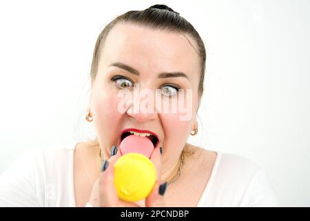 pump donna mordente pasta rosa ridendo bloccato lingua ha sollevato gli occhi interessante divertente su uno sfondo bianco posto per il testo gioioso Foto Stock