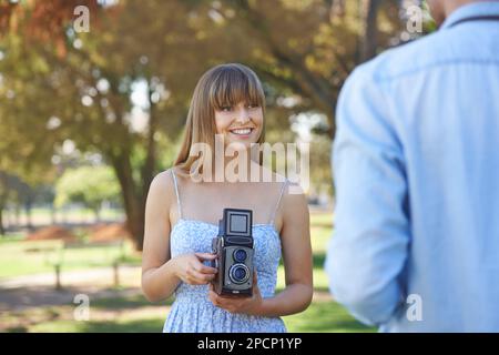 Condividere l'amore e la passione per la fotografia. una giovane coppia che scatta foto all'esterno con fotocamere d'epoca. Foto Stock