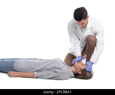 Medico in uniforme praticando il primo soccorso su donna su sfondo bianco Foto Stock