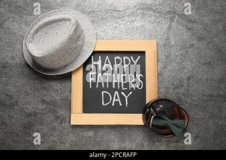 Lavagna con frase Happy Father's Day e accessori per gli uomini su sfondo grigio, piatto Foto Stock