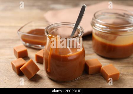 Gustoso caramello salato e caramelle su tavola di legno Foto Stock