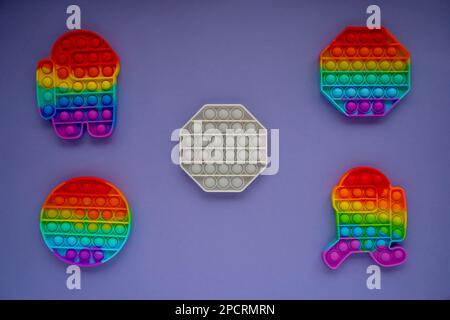 Giochi pop it trendy in forma di figure geometriche, e un personaggio tra noi su uno sfondo molto Peri. Giochi per bambini Foto Stock