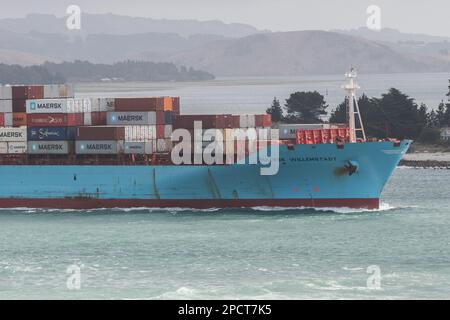 Una nave da carico carica passa attraverso una baia nell'isola meridionale di Aotearoa Nuova Zelanda. Foto Stock