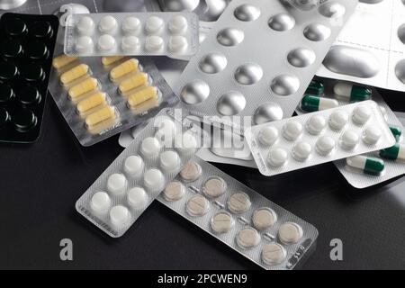 I medicinali e le pillole in blister sono sparsi sul tavolo Foto Stock