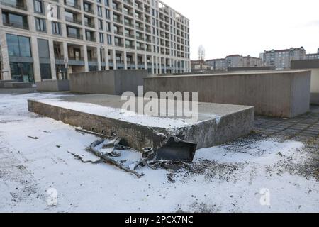 14 marzo 2023, Berlino: I detriti dell'auto che si è schiantata in una stele bassa del Memoriale dell'Olocausto il martedì sera si trovano sulla scena dell'incidente. Il famoso Memoriale dell'Olocausto di Berlino è stato danneggiato dall'impatto di un'auto. L'auto ha colpito il blocco basso del Memorial agli ebrei assassinati d'Europa vicino alla porta di Brandeburgo con grande forza il martedì sera. Secondo il rapporto, tre uomini erano fuggiti dalla polizia in macchina intorno alle 3:30 e poi scappati dalla strada. I sospetti hanno cercato di fuggire a piedi dopo l'incidente, ma sono stati arrestati dalla polizia dopo poco tempo. Al mattino, th Foto Stock