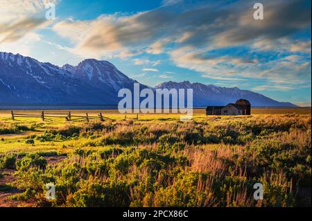 Tramonto su una storica fattoria a Mormon Row nel Grand Teton National Park, Wyoming Foto Stock