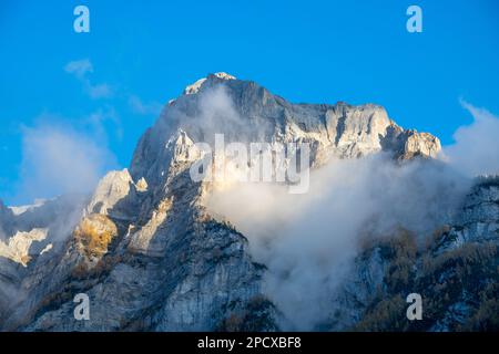 Impressionante formazione di montagna sotto il cielo blu circondato da nuvole Foto Stock