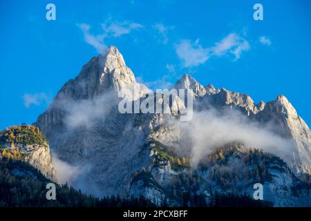 Impressionante formazione di montagna sotto il cielo blu circondato da nuvole Foto Stock