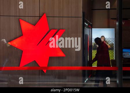 Un uomo dalla silhouette attende un ascensore vicino a un cartello con il logo della National Australia Bank (Nab bank) all'interno di un edificio nel New South Wales, Australia Foto Stock