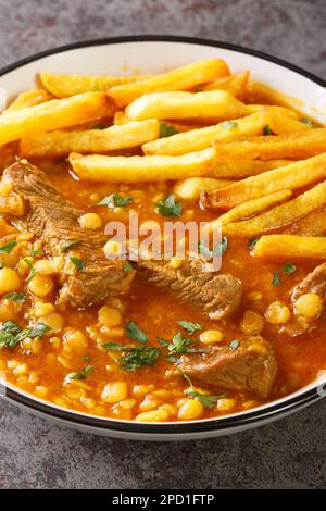 Carne di manzo Khoresh Gheymeh e stufato di pisello giallo con patate arrosto closeup su un piatto sul tavolo. Verticale Foto Stock