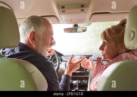 Uomo e donna senior che discutono mentre viaggiano in auto durante un viaggio su strada Foto Stock