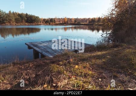 Una piattaforma in legno sulla riva di uno stagno o lago. Foto Stock