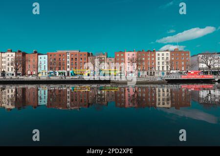 Dublino / Irlanda : gli edifici si riflettono in una calma acque del fiume Liffey lungo Ormond Quay a Dublino durante una giornata di primavera irlandese molto soleggiata Foto Stock