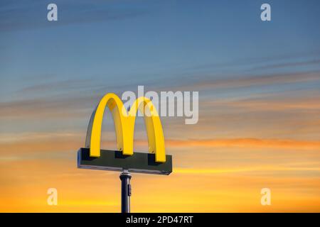 Il logo del McDonald's contro il cielo dell'alba dell'ora d'oro al ristorante McDonald's di Salo, Finlandia. Foto Stock