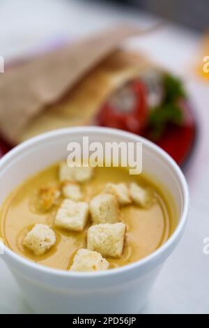 Zuppa gourmet di champignon con crostini croccanti servita in ciotola bianca nel ristorante fast food. Concetto di alimentazione sana Foto Stock