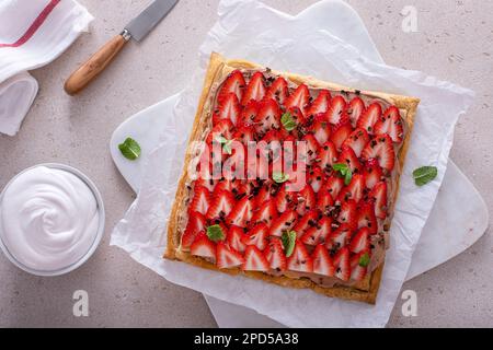 Crostata di fragole fresche e nocciole al cioccolato sulla pasta sfoglia vista dall'alto Foto Stock