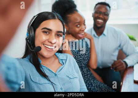 Selfie in ufficio, gli operatori del call center si pongono e si divertono, lavoro di squadra di successo Foto Stock