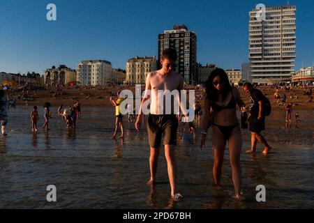 Gente che gode la bassa marea vicino al Molo occidentale sulla spiaggia di Brighton - Brighton & Hove, Sussex orientale, Regno Unito Foto Stock