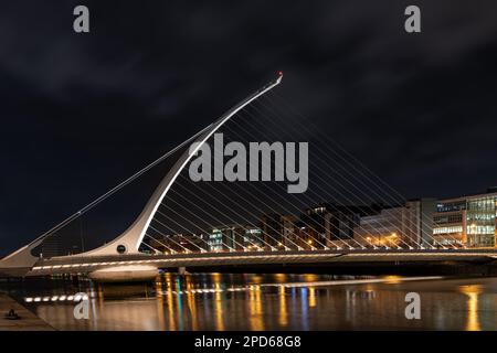 Il ponte Samuel Beckett sul fiume Liffey illuminato di notte (guardando a monte dalla riva sud), Dublino, Irlanda Foto Stock