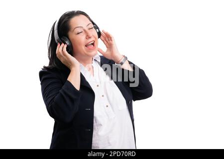 Felice imprenditore donna che indossa abbigliamento da ufficio ascoltare musica in cuffie cantando come concetto rilassante con vuoto copyspace isolato su bianco ba Foto Stock