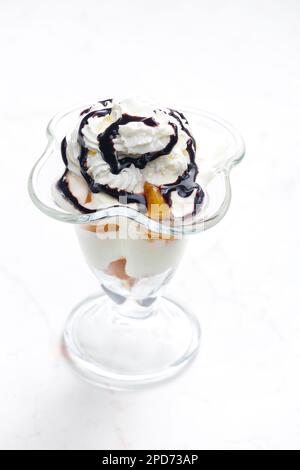 gelato con pesca stufata e panna montata Foto Stock