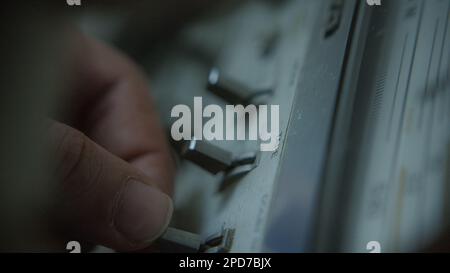 Primo piano colpo di dita umane premendo i pulsanti sul lettore di nastri Boombox Foto Stock