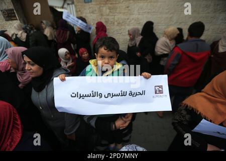 Città di Gaza, Palestina. 14th marzo 2023. Le donne palestinesi detengono la loro bandiera nazionale durante una manifestazione a sostegno dei prigionieri palestinesi detenuti nelle carceri israeliane, alcuni dei quali stanno osservando uno sciopero della fame, al di fuori del quartier generale della missione del Comitato Internazionale della Croce Rossa (CICR) a Gaza City. Foto Stock