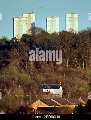 Glasgow, Scozia, Regno Unito 14th marzo 2023. UK Weather: Neve durante la notte e le docce di slittino si sono concluse e e un soleggiato tardo pomeriggio ha visto la città bagnata da light.The vecchio cottage in dawsholm parco è torreggiato dai grattacieli di maryhill in lontananza. Credit Gerard Ferry/Alamy Live News Foto Stock