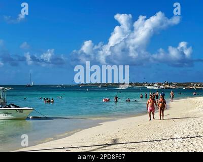 Palm Beach, Noord, Aruba - 10 marzo 2022. Persone in spiaggia e in acqua. Alberghi, resort e barche sullo sfondo. Foto Stock