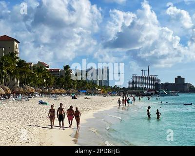 Palm Beach, Noord, Aruba - 10 marzo 2022. Persone in spiaggia e in acqua. Alberghi, resort e barche sullo sfondo. Foto Stock
