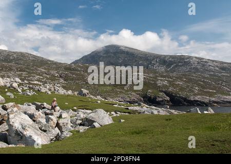 Book Reading Woman on Rocks a Mealasta, Lewis, Isola di Lewis, Ebridi, Ebridi esterne, Western Isles, Scozia, Regno Unito, Gran Bretagna Foto Stock