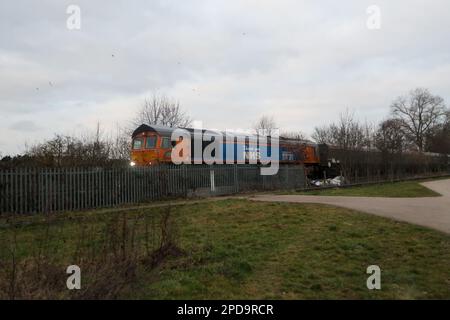 Classe 66 treno merci passando da Attenborough Nature Reserve a Nottingham con la livrea Thank you NHS. Foto Stock