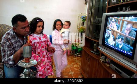 An Iraq family watches the trial of former Iraqi dictator Saddam Hussein on a state television, in Baghdad, Tuesday, Feb. 28, 2006. The trial of Saddam Hussein continued on Tuesday as defense lawyers attended a session, ending a monthlong boycott of the proceedings. Saddam and seven co-defendants have been on trial since Oct. 19 in the killing of nearly 150 people from the town of Dujail after a 1982 assassination attempt against Saddam there. (AP Photo/Hadi Mizban) .