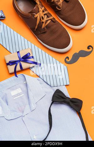 Composizione con scarpe maschio, camicia, accessori e regalo per la festa del papà su sfondo colorato, primo piano Foto Stock