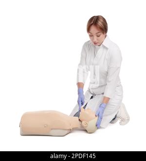 Medico in uniforme praticando il primo soccorso sul manichino su sfondo bianco Foto Stock