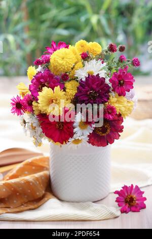 Vaso con bel bouquet, libro aperto e stoffa su tavolo di legno Foto Stock