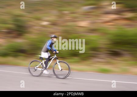 A velocità di corsa sulla sua bicicletta. Un giovane uomo in mountain bike in discesa. Foto Stock