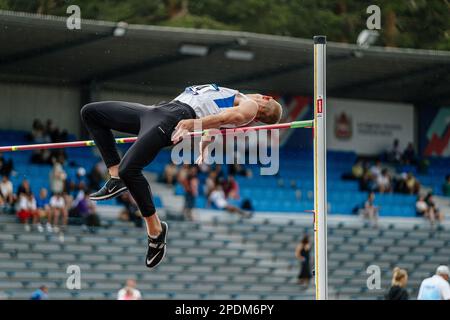 Jumper atleta maschile salto in pioggia, gara di atletica, scarpe Nike Spikes per il salto, giochi sportivi estivi Foto Stock