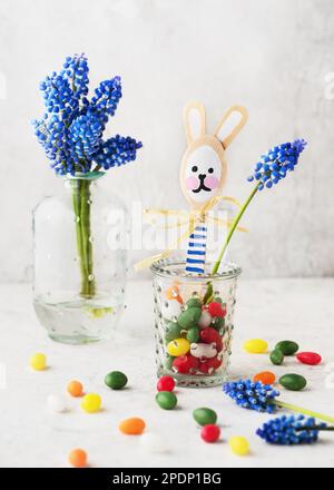 Carino coniglietto di pasqua fatto da cucchiaio di legno in piccolo vetro con dolci uova colorate caramelle. Articoli da regalo o decorazioni fatti a mano. Concetto di artigianato facile divertimento per bambini. Foto Stock