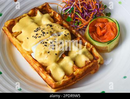 Uova Benedict (uova in camicia) su waffle belgi con salmone salato Foto Stock